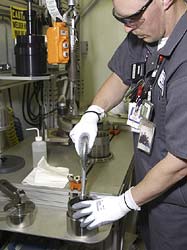 An FB Line employee works with part of the outer can welder process